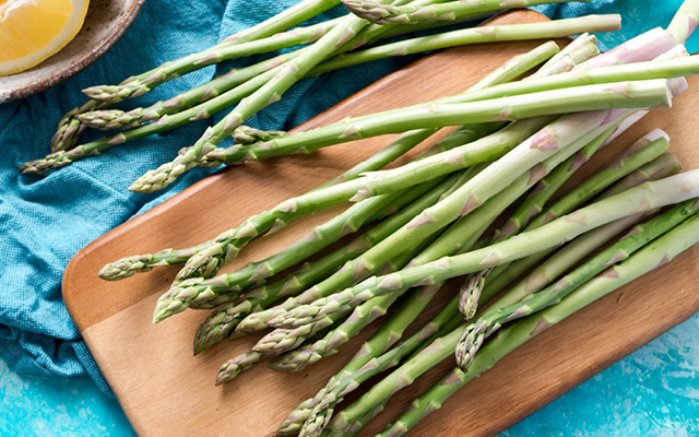 Asparagus on a cutting board with lemon